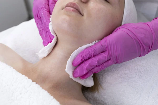 Cropped Cosmetologist Clears Skin Of Neck And Face Of Pretty Woman Before Beauty Procedure, Rejuvenation In Spa Saloon. Patient Getting Needle Mesotherapy, Flatly Skincare. Horizontal Plane.