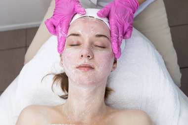 Güzellik salonundaki güzellik uzmanının cilt bakımı yapan güzel bir kadın. Yüz Kabuğu Maskesi, Güzellik Maskesi, Cilt Bakımı. Kozmetik Prosedür. Kozmetik ve Dermatoloji. Yatay Üst Görünüm