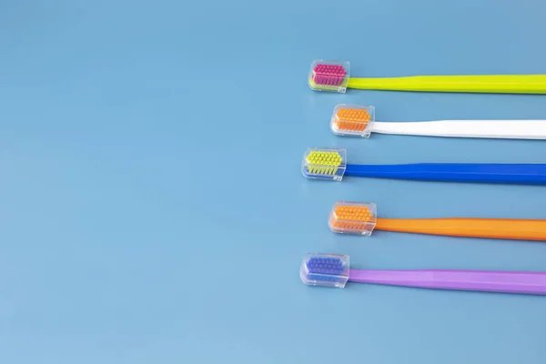 Design Ploché Lay Vícebarevné Zubní Kartáčky Modrém Pozadí Kopírovat Prostor — Stock fotografie
