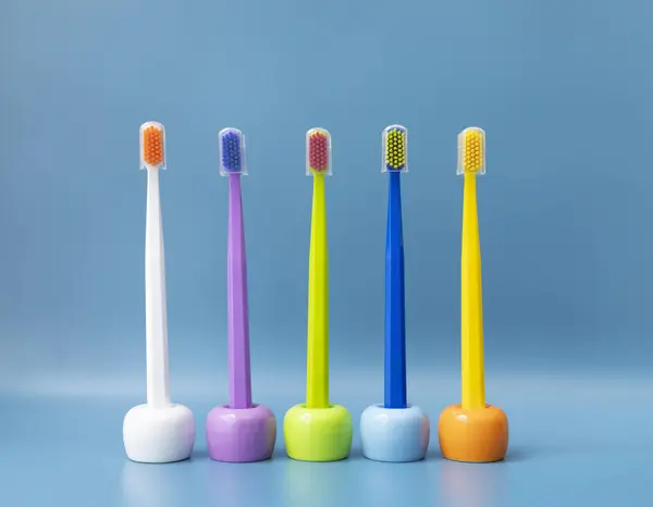 大量色彩艳丽的牙刷出现在书架上 在蓝色背景的书架上 早上的卫生 浴室配件 牙齿健康护理 水平平面的 高质量的照片 — 图库照片