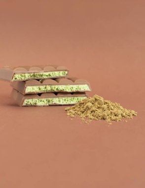 Kahverengi kenevir çikolatası ve kahverengi arka planda yeşil kenevir tozu. Metin için Boşluğu Kopyala. Dikey düzlem. Yüksek kalite fotoğraf