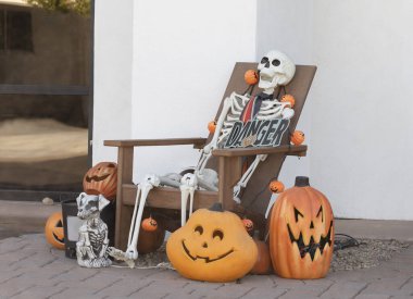 İskelet Sandalyede, Yüzü Olmuş Balkabağı Korkunç Köpek ve Kafatası Cadılar Bayramı 'nın geleneksel özellikleridir. Cadılar Bayramı partisi için açık hava süslemesi. Yatay düzlem. Yüksek kalite fotoğraf