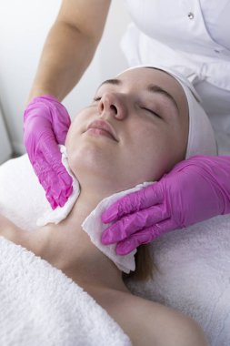 Güzellik Uzmanı Kadın Suratı, Boyun Derisi Kuaför Salonunda Güzellik Uygulamasından Önce Pamuk Pedleri Kullanıyor. Micellar Suyla Cilt Temizleme. Genç bayan yüz derisinin tadını çıkartıyor. Dikey.