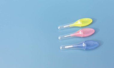 Mavi arka plandaki dişlerin arasını temizlemek için renkli diş fırçası. Yumuşak tüylü kürdan, Ağız temizleme aleti. Yatay, Metin için Boşluğu Kopyala. Diş ve Ortodontik.