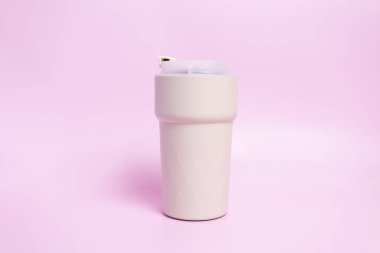 Seyahat Kahvesi Pembe Arkaplanda Bej Kupa, Termo Sıcak Kahve Tumbler, Mühürlü Yeniden Kullanılabilir Çay Fincanı, Toka, Pembe Arkaplanda Süpürgesiz Çelik Kupa, Mockup. Soğuk ya da Sıcak İçecekler.