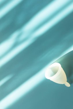 Mockup Silicone Lastik Yeniden Kullanılabilir Aybaşı Kupasını Gölgelerle Mavi Arkaplanda, Metin için Boşluğu Kopyala. Dümdüz. Akış Akışı özümseniyor. Kişisel mahremiyet hijyeni. Adet döngüsü, jinekoloji. Dikey.