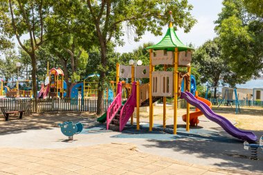 Renkli Parlak Çocuklar Bahçesi. Küçük çocuklar sıcak bir günde Yeşil Park 'ta oyun oynarlar. Tırmanma Duvarı, Tırmanma Çerçeveleri. Yaz tatili, eğlence, oyunlar, aile yürüyüşü, hiç kimse. Yatay.