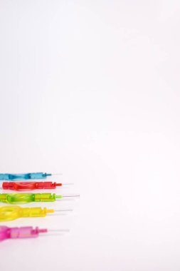 Mockup birçok renkli diş fırçası, diş fırçası açısını diş temizleme için kürdan, sarı şeftali arkaplanındaki diş tellerini izole etti. Dişçilik, ağız sağlığı hijyeni. Boşluğu Kopyala Ağız Fırçası.