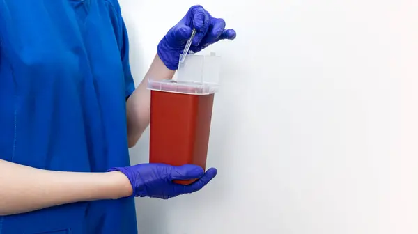 Mockup Doctor Ampule in Sharps konteynırında iğneyi imha ediyor. Bulaşıcı atıklar için çöp konteynırı, tıbbi atık imhası. Biyolojik tehlike için sivri uçlu küçük tıbbi plastik kutu. Boşluğu Kopyala
