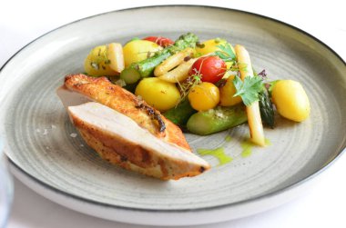 Kızarmış tavuk göğsü, sebze tabağı, bir restoranda servis edilen yemek.