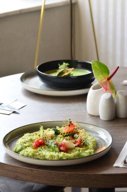 Gıda geçmişi güzel, yeşil kremalı kuşkonmaz risotto, restoranda servis ediliyor. dekore edilmiş