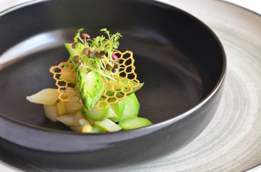 kuşkonmaz salatası yeşil ve beyaz kuşkonmaz siyah kasede, sağlıklı yiyecekler.