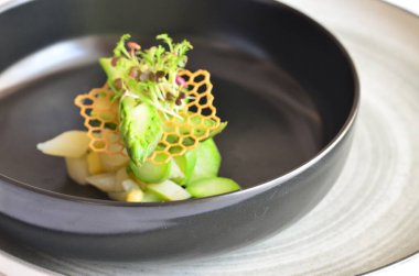 kuşkonmaz salatası yeşil ve beyaz kuşkonmaz siyah kasede, sağlıklı yiyecekler.