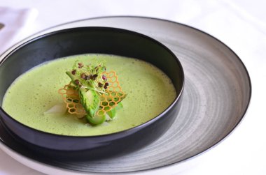 Siyah tabakta yeşil çorba. Yaklaş..