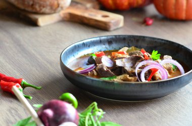 Etten, karaciğerden, omuzdan ve kalpten oluşan gerillalar, geleneksel Çek kasap gerillaları, tahtadan bir masada, yemek arkaplanda, siyah bir tabakta yemek servisi yaptılar.