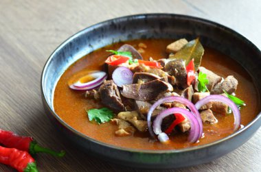 Etten, karaciğerden, omuzdan ve kalpten oluşan gerillalar, geleneksel Çek kasap gerillaları, tahtadan bir masada, yemek arkaplanda, siyah bir tabakta yemek servisi yaptılar.