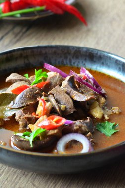 Gulaş, karaciğer, omuz ve kalp parçalı yahni, geleneksel Çek kasabı kebabı, tahta bir masada siyah bir tabakta yemek servisi, yiyecek arka planı, yakın görüş.