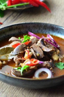 Gulaş, karaciğer, omuz ve kalp parçalı yahni, geleneksel Çek kasabı kebabı, tahta bir masada siyah bir tabakta yemek servisi, yiyecek arka planı, yakın görüş.