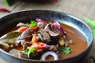 Gulaş, karaciğer, omuz ve kalp parçalı yahni, geleneksel Çek kasabı kebabı, tahta bir masada siyah bir tabakta yemek servisi, yiyecek arka planı, yakın görüş.