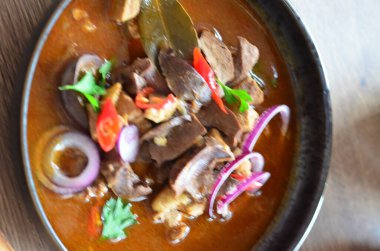 Geleneksel Çek usulü domuz güveci, siyah tabakta servis ediliyor, içeriği de...