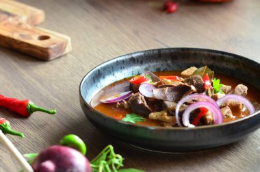 Geleneksel Çek usulü domuz güveci, siyah tabakta servis ediliyor, içeriği de...