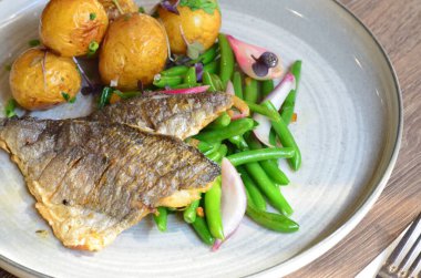 Patatesli balık, yeşil bezelye ve bezelye.