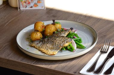 Patates ve sebzeli kızarmış balık.