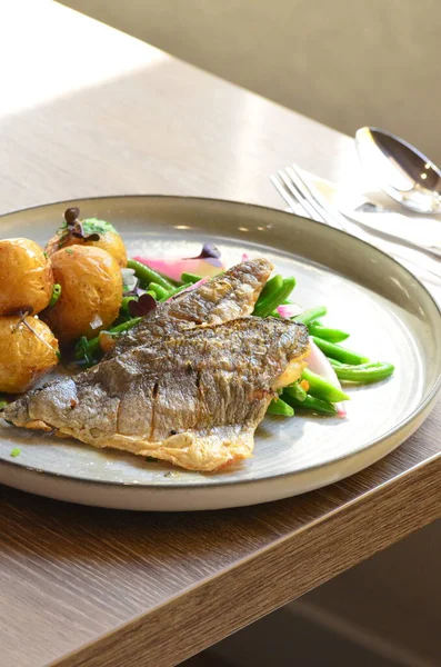 fish sea bream filet with green beans, serving food in restaurant