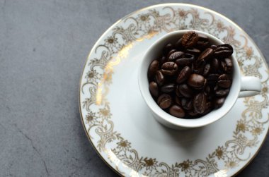 Kahve fincanı siyah bir masada. Kahve çekirdeği. Kahve fincanı.