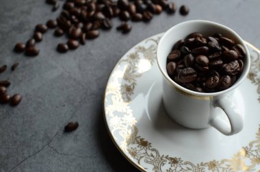 Bir fincan kahve, kavrulmuş kahve çekirdekleri ve sade kahve.