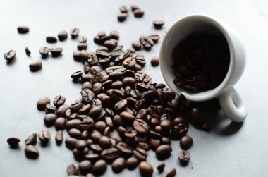 Kahve fincanı ve siyah arka planda kahve taneleri..