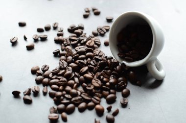 Kahve çekirdekleri ve fincanlar beyaz masada. Kopyalama alanı olan üst görünüm.