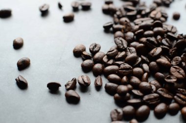 Beyaz arka planda beyaz bir fincanda kahve çekirdekleri.