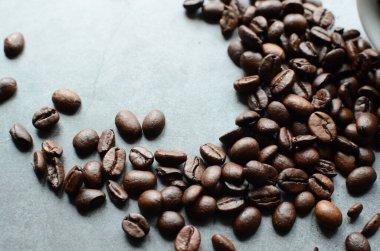 Bir fincan sade kahve ve ahşap bir arka planda fasulye.