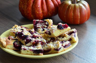 Balkabaklı ev yapımı turta, ahşap bir tabakta elmalar ve erikler.