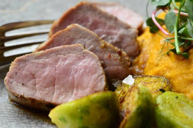 Kızarmış domuz, patates püresi ve sebze.