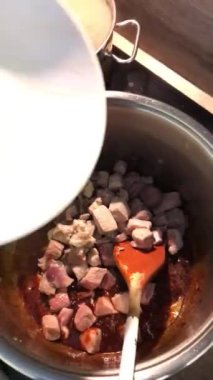 Gulaş, karaciğer, omuz ve kalp parçalı yahni, geleneksel Çek kasabı kebabı, tahta bir masada siyah bir tabakta yemek servisi, yiyecek arka planı, yakın görüş.