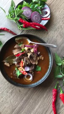 Gulaş, karaciğer, omuz ve kalp parçalı yahni, geleneksel Çek kasabı kebabı, tahta bir masada siyah bir tabakta yemek servisi, yiyecek arka planı, yakın görüş.