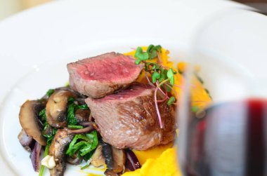 Izgara biftek ve kuzu biftek, yanında da portakal şarabı.