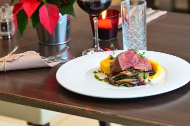 Restoranda beyaz bir tabakta mantar soslu biftek fileto.