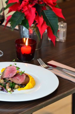 Orta boy biftek, restoranın arka planında Noel atmosferi.