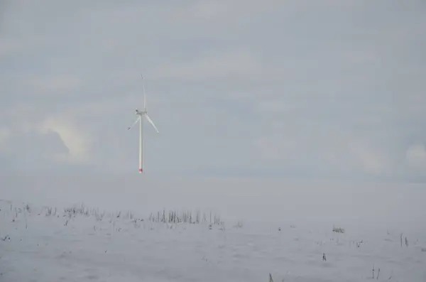 a wind turbines in a snow covered field. high quality photo