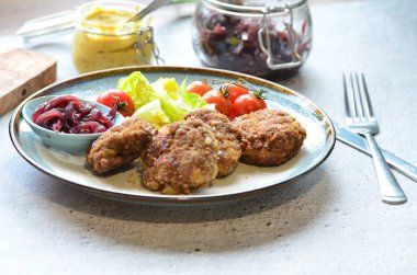 Salata ve domatesli bir tabakta köfte. Seçici odak.