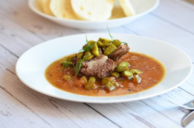 Sığır eti yahnisi, salatalık sosu, ekmek köftesi, geleneksel Çek mutfağı, hafif arka planda servis edilen yiyeceklerin arka planı.