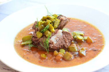 Sığır eti yahnisi, salatalık sosu, ekmek köftesi, geleneksel Çek mutfağı, hafif arka planda servis edilen yiyeceklerin arka planı.