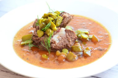 Sığır eti yahnisi, salatalık sosu, ekmek köftesi, geleneksel Çek mutfağı, hafif arka planda servis edilen yiyeceklerin arka planı.