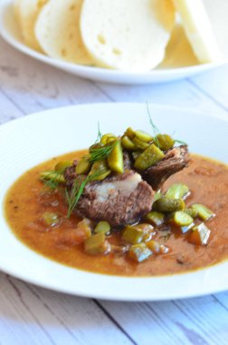 Sığır eti yahnisi, salatalık sosu, ekmek köftesi, geleneksel Çek mutfağı, hafif arka planda servis edilen yiyeceklerin arka planı.