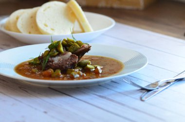 Kullanılmış et ışıklandırması, sığır eti güveci, salatalık sosu, ekmek köftesi, geleneksel Çek mutfağı, hafif arka planda servis edilen yiyeceklerin arka planı.