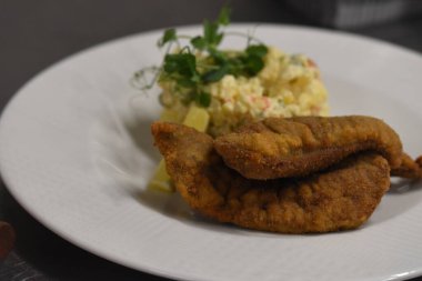 Bir tabak yemek, çatal ve salata.