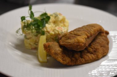 Limonlu bir tabak yemek ve patates püresi.